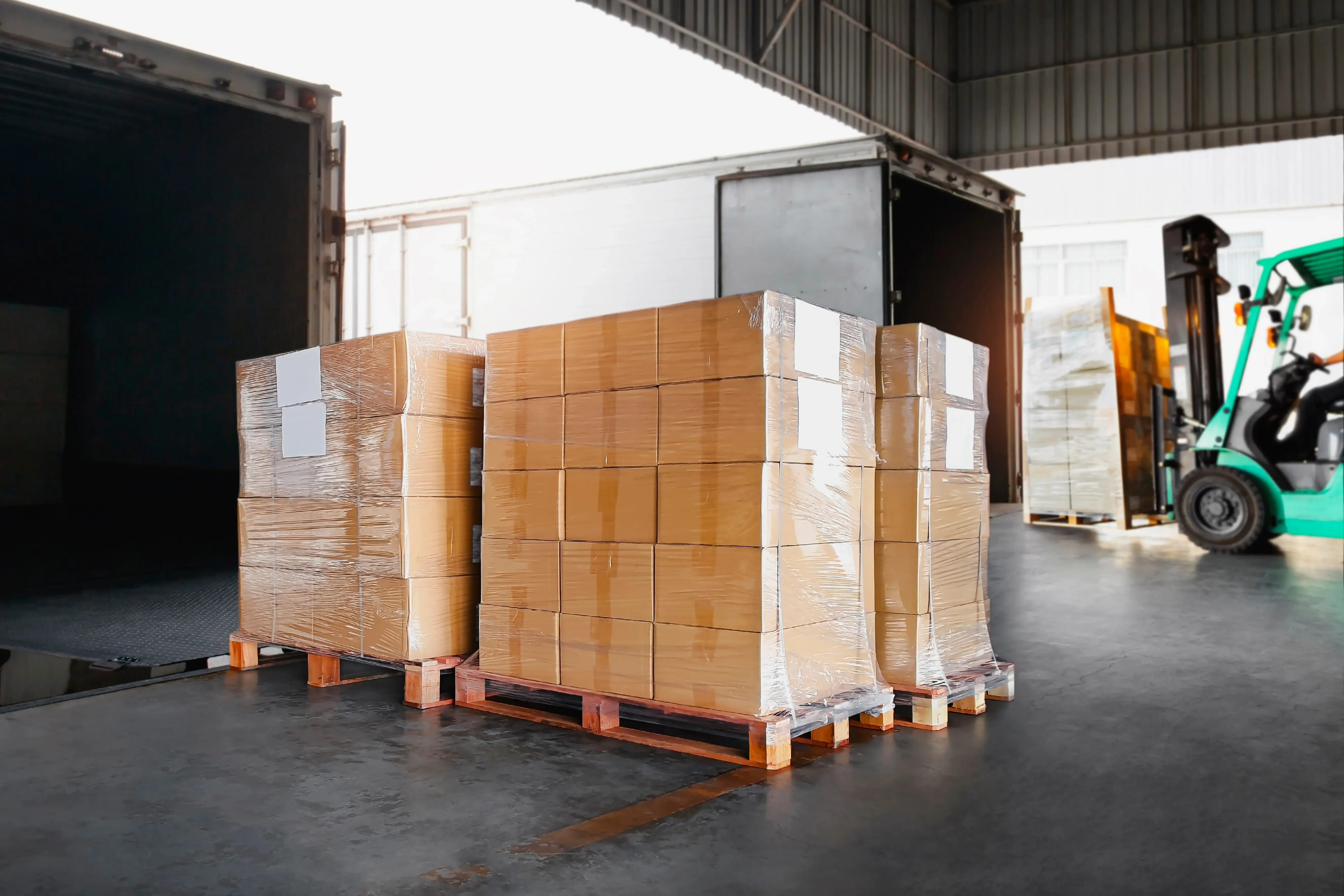 Forklift moving pallets in a warehouse as part of a consolidated freight shipment for efficient transport.