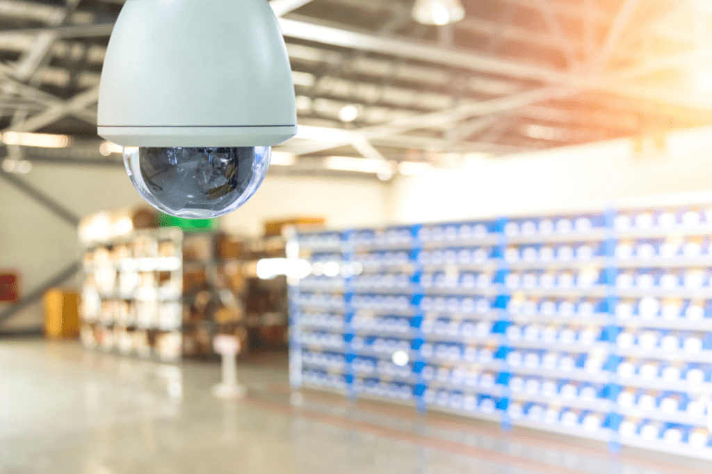 Secure warehouse facility with gated yard, surveillance cameras, and loading ramp.