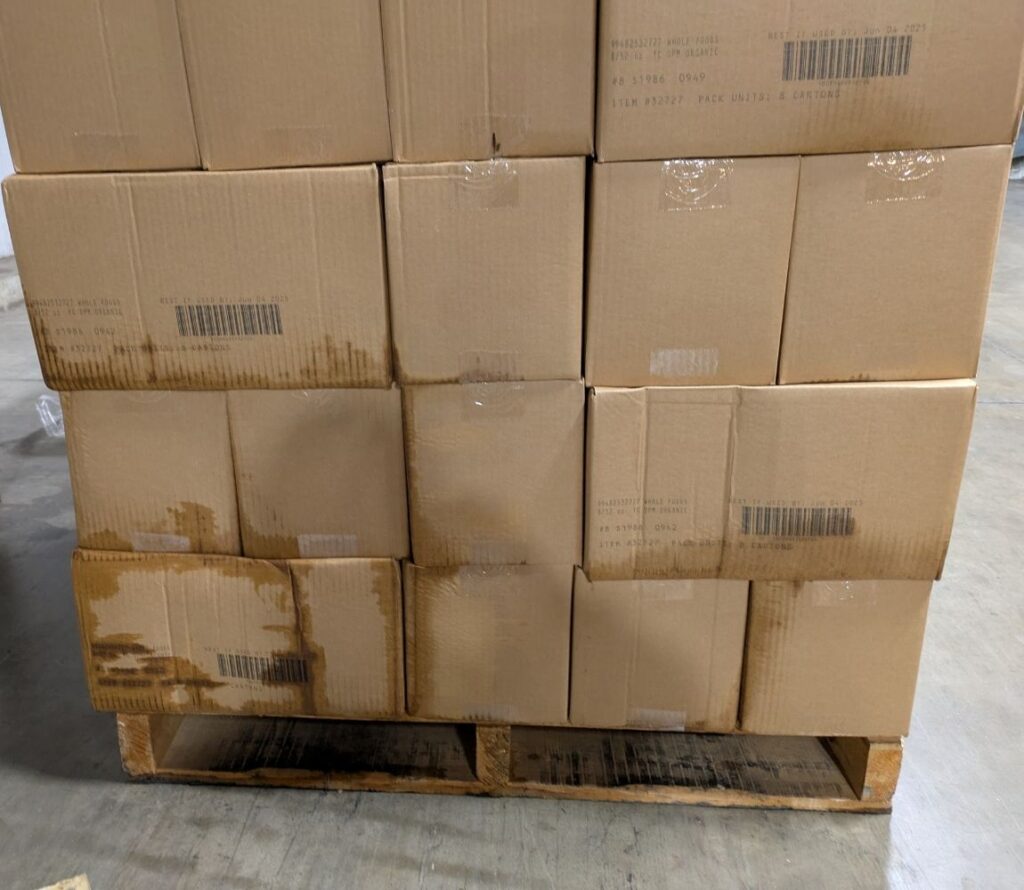 Workers restacking and securing pallets in Lancaster warehouse