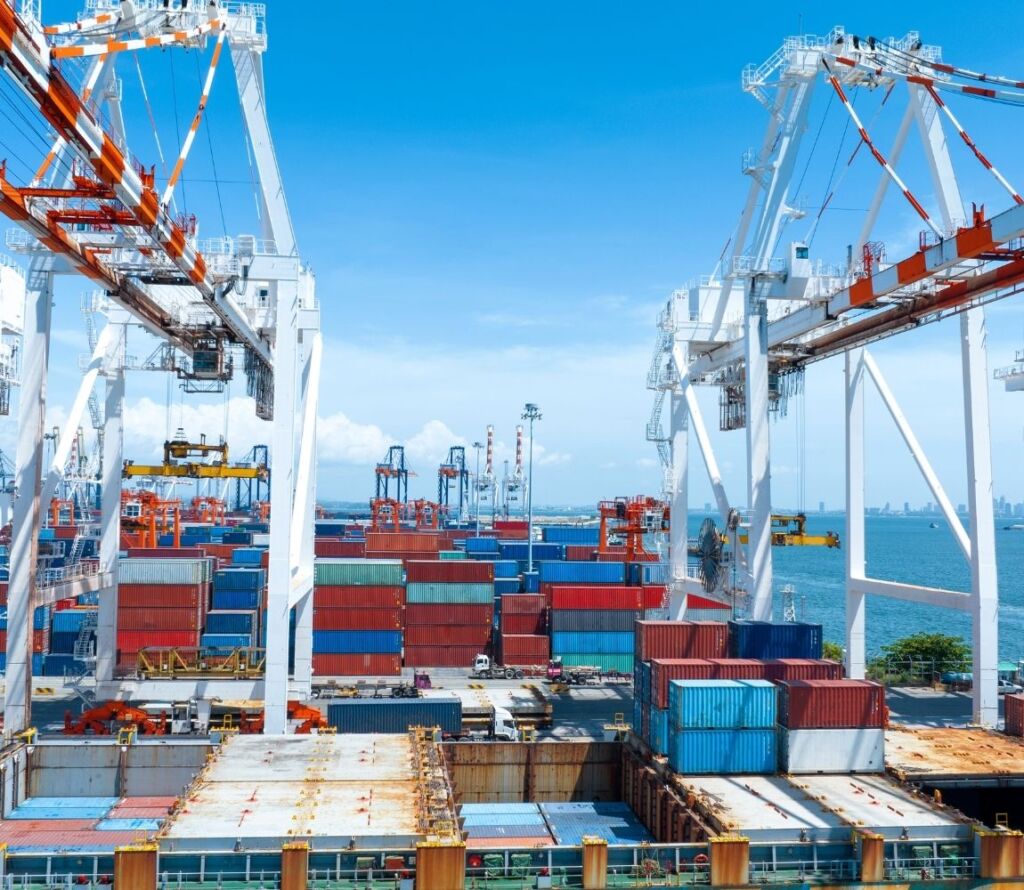 Freight containers and trucks transferring cargo near major highways.